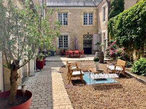 een binnenplaats met stoelen en tafels en een huis bij Chambre Alix in La Flèche
