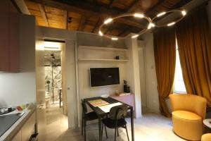 a kitchen and dining room with a table and a television at Casa Mandelli in Alba
