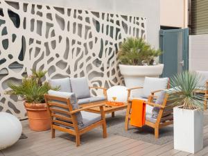 um pátio com duas cadeiras, uma mesa e plantas em Holiday Inn Toulouse Airport by IHG em Blagnac