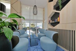 una fila di sedie blu in una sala d'attesa di Hotel Kornati a Biograd na Moru