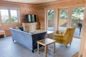 un soggiorno con divano blu e 2 sedie di Transylvania Mountain Chalet a Bran