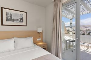 a hotel room with a bed and a balcony at Gallery Central Piraeus Port in Piraeus