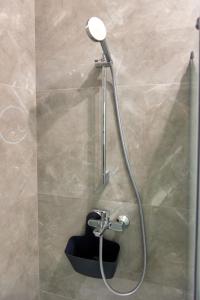 een douche met een douchekop in de badkamer bij Studio Aquarium Stefan Resort in Mamaia Nord – Năvodari