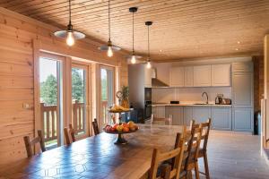 una cucina e una sala da pranzo con tavolo e sedie di Transylvania Mountain Chalet a Bran