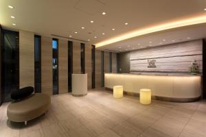a lobby with a chair and a counter in a building at Solaria Nishitetsu Hotel Ginza in Tokyo