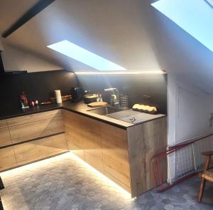 an attic kitchen with a sink and a skylight at Apartamento Puigcerdà ideal familias in Puigcerdà