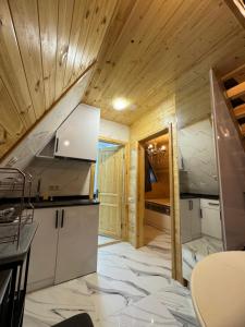 a small kitchen with wooden walls and wooden ceilings at Villa Edelweiss in Batumi