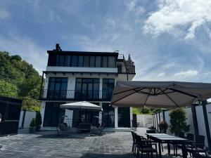 two tables and umbrellas in front of a building at Villa Edelweiss in Batumi