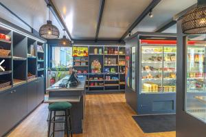 a grocery store with a counter and a refrigerator at Mobilhome moderne avec grande terrasse, pergola, HUDIMESNIL in Hudimesnil