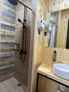 a wooden bathroom with a sink and a shower at Hotel Eurica in Kutaisi