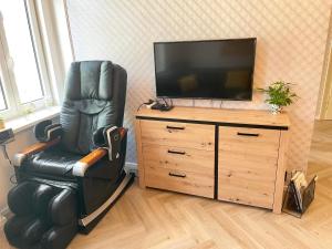 a black leather chair sitting in front of a television at Apartment Nicol in Karlovy Vary