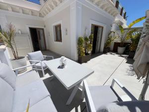 eine Terrasse mit weißen Stühlen und einem weißen Tisch in der Unterkunft La Puerta de Nerja BOUTIQUE - Adults Recommended in Nerja