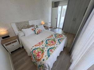a bedroom with a bed with a floral comforter at La Puerta de Nerja BOUTIQUE - Adults Recommended in Nerja