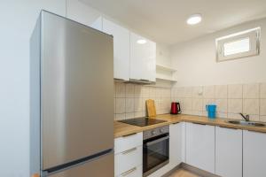 eine Küche mit weißen Schränken und einem Kühlschrank in der Unterkunft XXL Apartment - Private Pool in Omiš