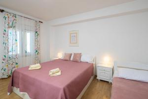 ein Schlafzimmer mit einem rosa Bett mit zwei Handtüchern darauf in der Unterkunft XXL Apartment - Private Pool in Omiš