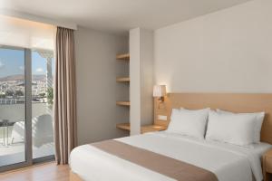 a hotel room with a bed and a balcony at Gallery Central Piraeus Port in Piraeus