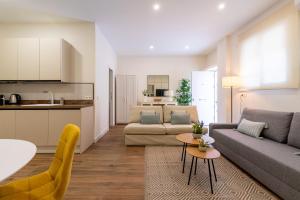 ein Wohnzimmer mit einer Couch und einem Tisch in der Unterkunft Apartamento Boutique a estrenar in Sevilla