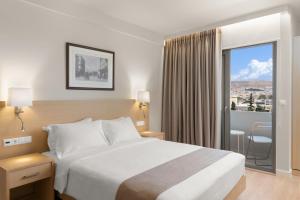 a hotel room with a bed and a balcony at Gallery Central Piraeus Port in Piraeus