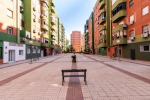 eine Bank mitten auf einer leeren Straße in der Unterkunft Apartamento Boutique a estrenar in Sevilla
