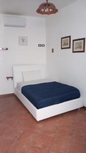 a bed in a white room with a blue mattress at A casa SCALILLA in Palermo