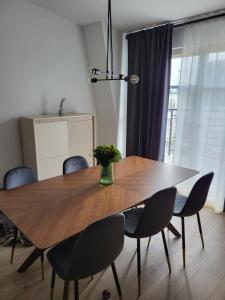 stół jadalny z krzesłami i wazonem kwiatów na nim w obiekcie Sopot Apartament w mieście Sopot