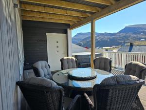 a patio with a table and chairs on a balcony at Nord Hus Service AS, Deluxe, Sauna, Jakuzzi in Havøysund