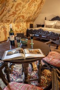 un tavolo con un libro e una bottiglia di vino di Hotel Ruze a Cesky Krumlov