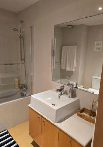 W łazience znajduje się biała umywalka i lustro. w obiekcie Studio Estádio do Dragão w Porto