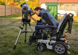 a woman sitting in a chair in front of a camera at Ferienhäuser im Sternenpark in Lochow