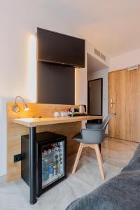 een bureau en een stoel in een kamer met een koelkast bij Hotel Tříška in Brandýs nad Labem