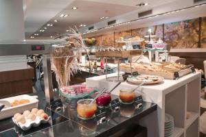 a breakfast buffet with eggs and pastries on a counter at Barcelona Hotel Colonial in Barcelona
