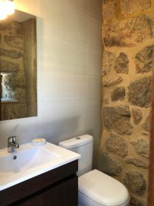 een badkamer met een wastafel en een stenen muur bij CASA MOTA in Lobios
