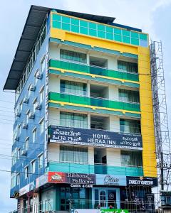 HOTEL HERAA INN في منغالور: مبنى طويل مع لوحات ملونة عليه