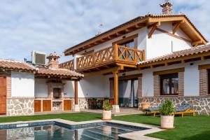 een villa met zwembad en huis bij Arandas Village in Navahermosa