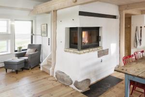 a living room with a fireplace in a house at Urgemütliche Reetdachkate mit großem Kamin und Sauna in Pommerby