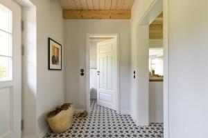 a hallway with a white door and a tile floor at Wildhagen 1 in Holzdorf