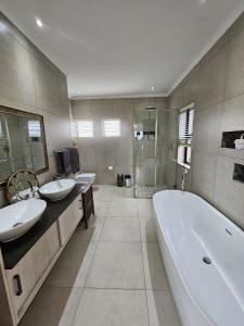 a bathroom with two sinks and a tub and a shower at Langebaan Golf Estate - Signature Hole 24hrs power in Langebaan