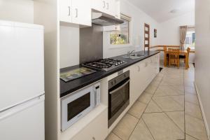 a kitchen with white cabinets and a stove top oven at BIG4 Middleton Beach Holiday Park in Albany