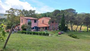 ein Haus auf einem Hügel mit einem grasbewachsenen Feld in der Unterkunft Allulivus in Montenero