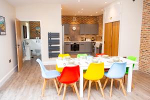 a dining room with a white table and colorful chairs at The Kennels in Hexham
