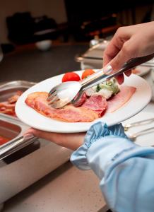 a person holding a plate of food with a fork and knife at Ta' Tereza In Manwel Dimech in Sliema