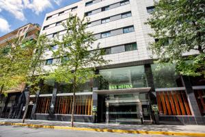 een gebouw met een boom ervoor bij B&B Hotel Ciudad de Lleida in Lleida