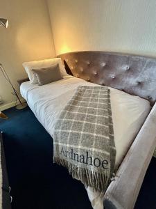 a bed with a blanket on it in a room at Lochindaal Hotel in Port Charlotte