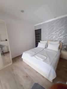 1 dormitorio con 1 cama con sábanas y almohadas blancas en "Vera old City" en Tiflis