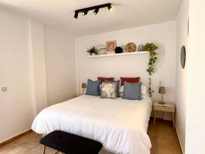 アギラスにあるChalet con Piscina Privada - La Cálidaのベッドルーム(白いベッド、青い枕付)