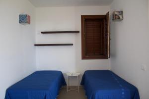 una stanza con due letti e una finestra di Le Casette a Favignana a Favignana