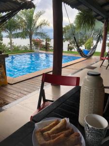 Ein Teller Brot auf einem Tisch neben einem Pool in der Unterkunft Chácara Por do Sol Beira Lago in Palmas