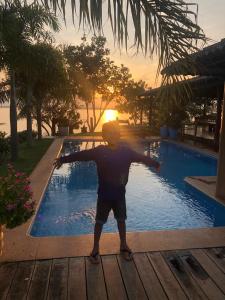 Ein Junge stand vor einem Schwimmbad. in der Unterkunft Chácara Por do Sol Beira Lago in Palmas + 26 Fotos