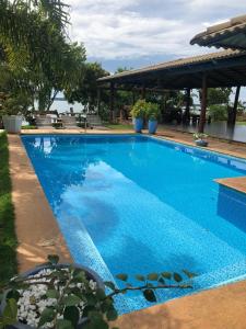 ein großer blauer Swimmingpool neben einem Gebäude in der Unterkunft Chácara Por do Sol Beira Lago in Palmas