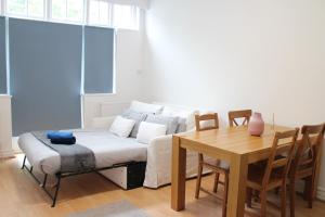 un salon avec un canapé et une table dans l'établissement Large Garden Apartment on Golders Green High Road, à Londres